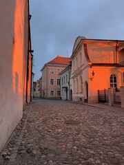 The cozy streets of Tallinn illuminated by sunset. The magical atmosphere of the Old Town in Tallinn, Estonia. The play of light and shadow before sunset.