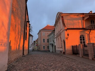 The cozy streets of Tallinn illuminated by sunset. The magical atmosphere of the Old Town in Tallinn, Estonia. The play of light and shadow before sunset.