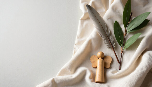 Scene from the Bible shows feather, branch, and wooden angel on draped cloth. Scene from the Bible conveys peace and spirituality with simple elegance.
