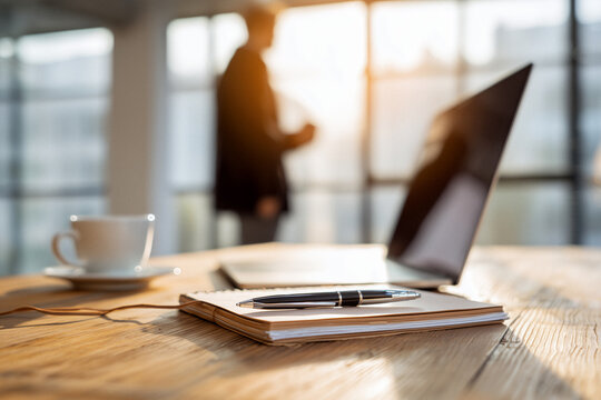Modernes B&uuml;ro mit Laptop, Kaffeetasse und Gesch&auml;ftspersonen im Hintergrund &ndash; Business und Produktivit&auml;t im Alltag
