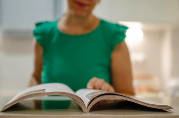 Woman reading cookbook for new kitchen recipe