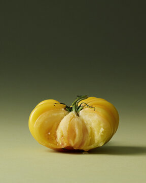 Yellow Heirloom Torn Tomatoes Painterly Still Life on Green Seamless background. Film grain