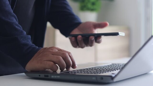 Cyber security 2FA login concept. Businessman working on laptop logging in on smartphone and modern device. The concept of remote work, freelancing, training, banking, online shopping. Cybersecurity.