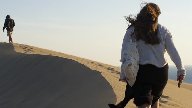 Man and woman walking on a sand dune in Patara beach in Turkey in slow motion