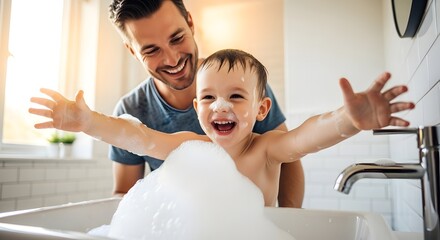 Father smiles as his young child splashes in a bubble bath, arms outstretched. Bathroom setting, natural light. Happy family moment.