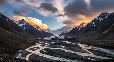 Majestic mountain valley with a winding river and dramatic clouds at sunset.