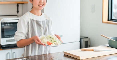 Children, girls, kids (smiling) holding vegetables in the kitchen
