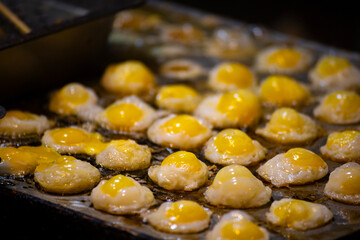 the process of cooking Roasted Bird Eggs (typically quail eggs) on a specialized grill pan