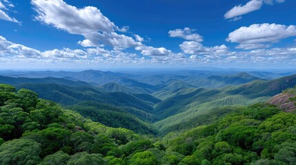 Fototapeta premium Vast Rolling Hills Covered in Lush Green Forests Under a Bright Blue Sky with Puffy White Clouds Bathed in Sunlight
