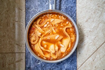 A classic Brazilian dish known as dobradinha, prepared with beef tripe, white beans, and tropical spices, served with traditional farofa made with toasted cassava flour.