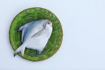 Fish in a basket, White Pomfret, fresh, free space, place for text, top view, white background