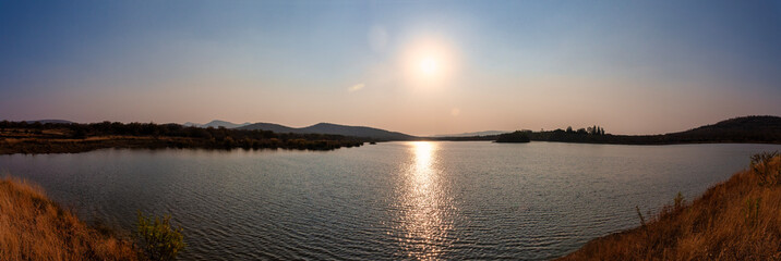 sunset over a body of water dam at Mokolodi Nature Reserve, located near Gaborone, Botswana