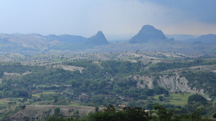 The dense forest in a valley looks beautiful against the backdrop of two towering hills