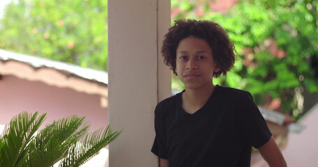 Young Hispanic boy of African descent with curly hair, close-up portrait outdoors with natural...