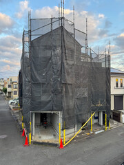 住宅の外壁塗装のための足場と黒いネット