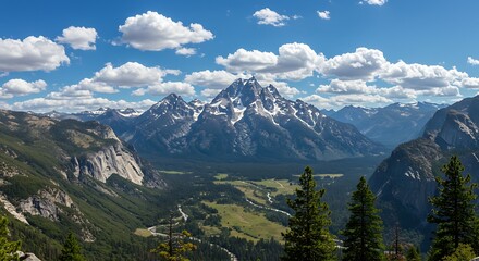 Obraz premium Breathtaking panoramic view of a majestic mountain range under a blue sky with fluffy white clouds.