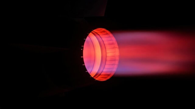 Powerful bright jet engine exhaust with flames, vibrant light and dark background. Technology and transport concept.