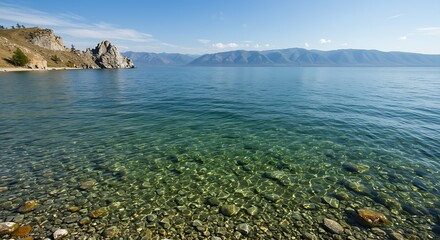 Crystal Clear Waters of Lake Baikal with Rocky Shoreline and Distant Mountains.