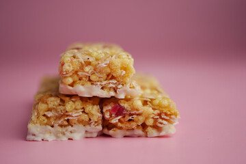 Delicious snack bars stacked against a pink background