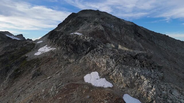 Majestic Rocky Mountain Peak with Snow Patches under Blue Sky in British Columbia, Canada