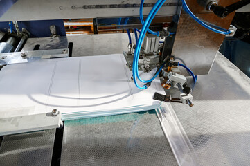 Innovative paper sheet feeding mechanism enhances efficiency in glue-spreading processes for a streamlined production environment