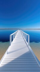 White Wooden Pier Extending Into Calm Deep Blue Sea Under a Clear Bright Sky with Sparkling Water and Sandy Shoreline