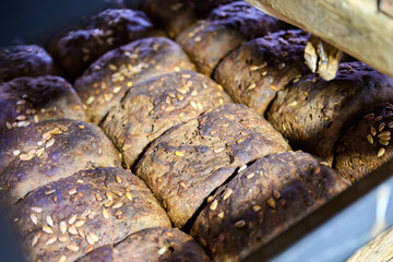 Freshly baked bread loaves arranged in wooden trays at a bakery plant during the early morning hours