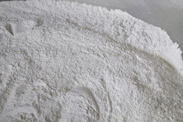 White wheat flour spread across a clean surface ready for baking or cooking preparations in a kitchen setting