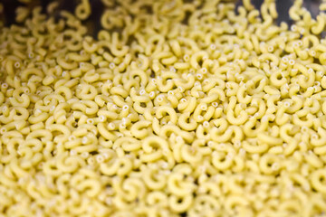 Pasta manufacturing process with fresh macaroni shapes ready for cooking in a food production facility