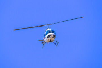 Photograph of a tourist sightseeing helicopter flying around a sporting event in regional Australia.