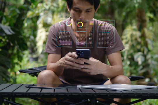 Young Man Analyzing Data on Smartphone in Nature Setting