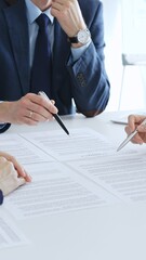 Business colleagues reviewing contract documents during an office meeting, discussing terms, and preparing for agreement signing, focusing on legal consultation and partnership discussion
