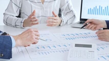 Business people analyzing financial data and market trends during a corporate meeting, collaborating on reports and planning strategic growth in modern office