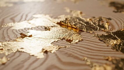 Close up view of shimmering gold leaf flakes scattered on a textured light wooden surface with wavy grain patterns creating a luxurious and elegant background - Powered by Adobe