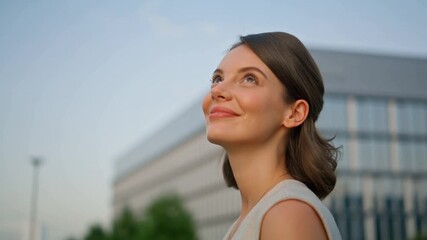 A young woman gazes upward with a hopeful expression, a symbol of ambition and aspiration Stock Video