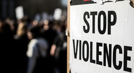 Protesters rally for peace with 'Stop Violence' banner in blurred crowd