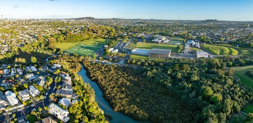 Aerial view of Seddon fields, Auckland, New Zealand, showcasing a blend of residential areas, sports fields, and natural landscapes. The image captures the urban sprawl meeting green spaces.