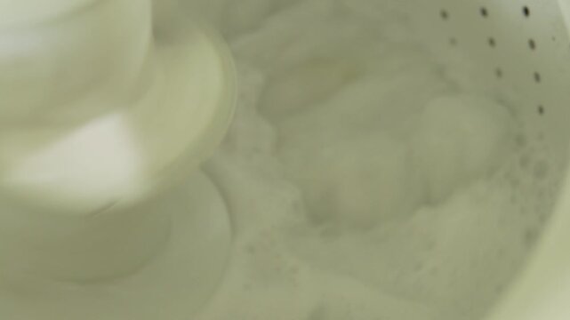 Washing machine agitator washing clothes with soap