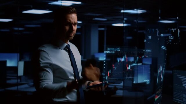 A focused man analyzing financial data in a modern office, filled with technology Stock Video