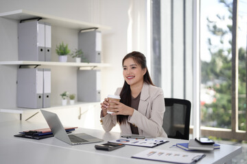 Asian Businesswoman Relaxing Coffee Break Modern Office Setting Professional Female Taking Moment Thoughtful Entrepreneur Desk Workspace