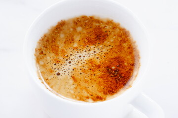 淹れたてのコーヒー（カフェラテ）が入ったコーヒーカップを、真上から俯瞰した画像
