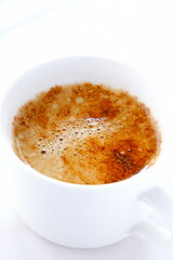 淹れたてのコーヒー（カフェラテ）が入ったコーヒーカップを、真上から俯瞰した画像
