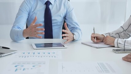 Business colleagues strategizing in modern workspace, reviewing financial analytics on digital devices, sharing insights through collaborative teamwork and data driven discussion - Powered by Adobe