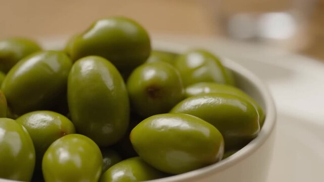 Close-up shot of a bowl of fresh, green olives, showcasing their vibrant color and texture Stock Video
