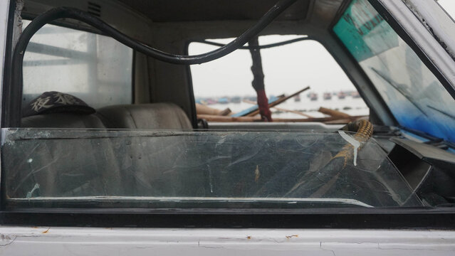 capture pick up car waiting for fish basket for sending on tradisional market soon on indonesia with blurry background tradisional fishman ship dan beach.