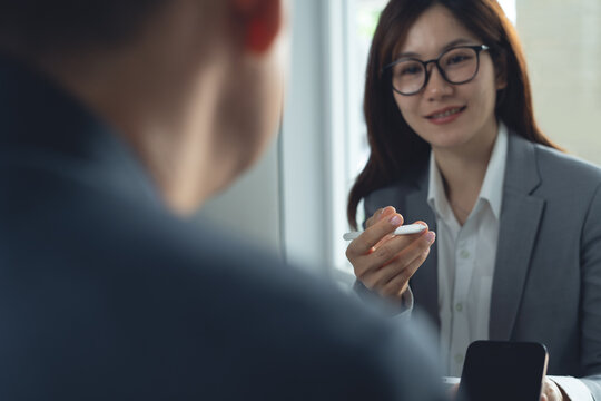 Two businessmen having a discussion with colleague, working on laptop computer, using digital tablet during meeting at office. Business planning and solution, working together concept