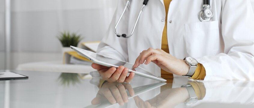 Female doctor using digital tablet, providing modern healthcare and medical technology consultation. Medicine, healthcare and science concept
