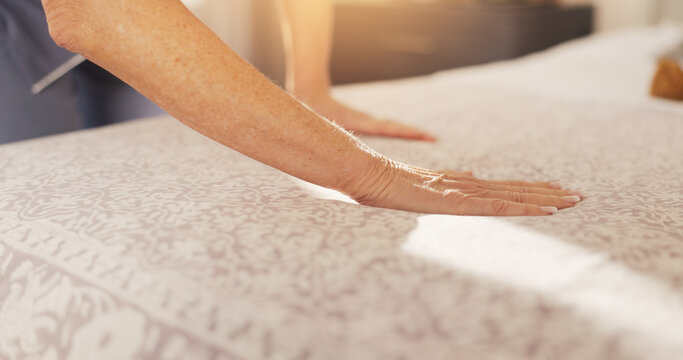 Hands, person and cleaning bed at house to start day, dusting bedding and household chores. Mature woman, sheets and tidy bedroom for hygiene, blanket maintenance and organizing duvet of housekeeping