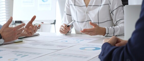 Business meeting with colleagues discussing financial charts, strategy planning, and analyzing data reports during a professional teamwork collaboration session