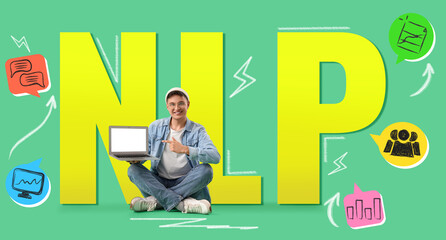 Young man pointing at blank laptop on green background